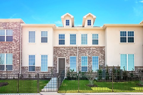 a large brick building with a grassy yard in front of it